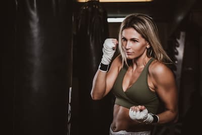 Mladá žena boxuje do boxovacího pytle