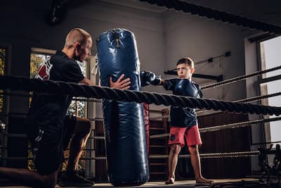 Chłopiec trenujący MMA z trenerem na siłowni