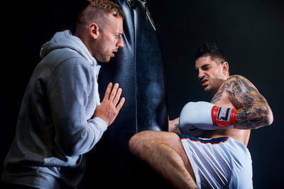 muž podporuje boxera pro tréninku do boxovacího pytle